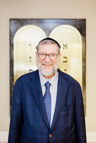 Man in a suit smiling in facility interior