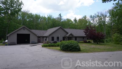 Exterior view of a senior living facility surrounded by trees