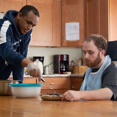 Staff assisting a resident with a meal