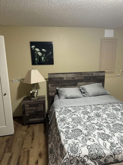 Cozy resident room with a decorative bed and lamp.