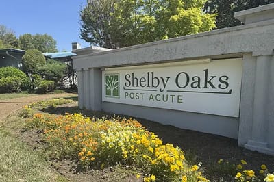 Exterior sign of Shelby Oaks Post Acute with flowers