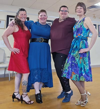 Four women celebrating in a common area.