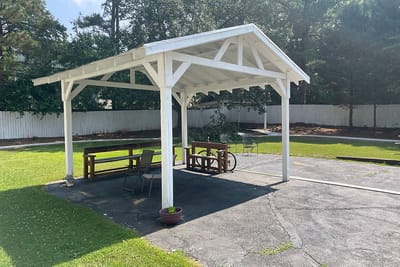 Outdoor shaded seating area with benches.