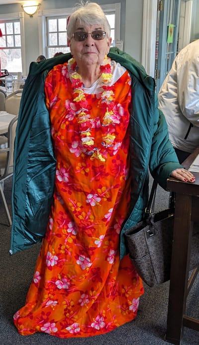 Resident in a vibrant floral outfit with a lei.