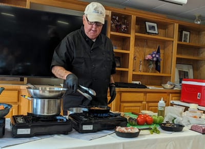 Chef preparing food in a communal cooking activity.
