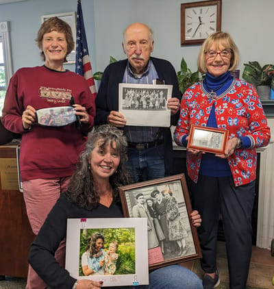 Residents holding photographs and sharing memories.