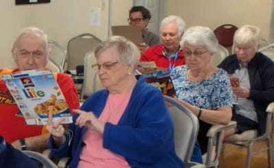 Residents engaged with reading materials in the common area.