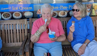 Two residents enjoying ice cream on a bench.