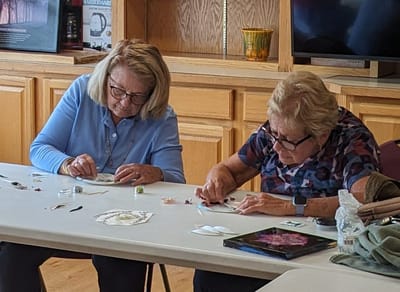Residents engaged in a craft activity at a table.