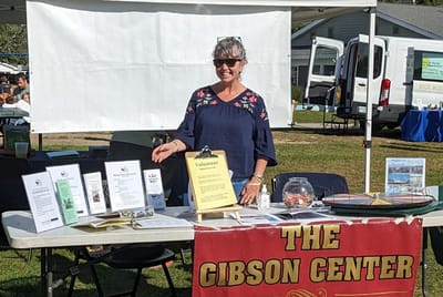 Volunteer at an outdoor booth with promotional materials