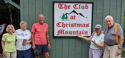 Group of residents smiling in front of a sign