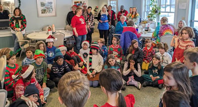 Children performing for senior residents during a holiday event.