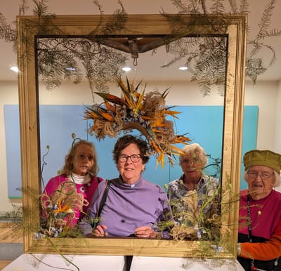 Residents enjoying an art activity with a decorative frame.