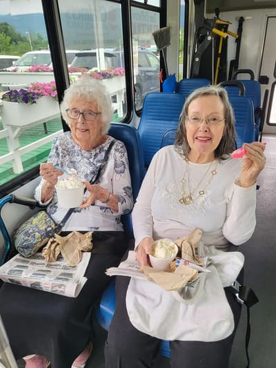Two residents enjoying ice cream on a bus