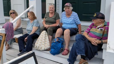 Group of residents sitting on facility steps.