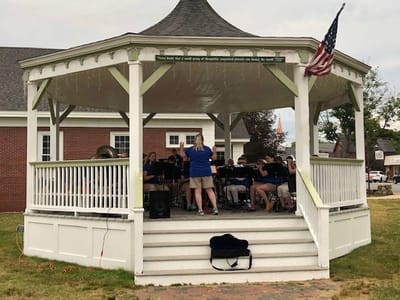 Residents enjoying a band performance in a gazebo