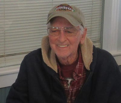Smiling elderly man in casual attire.