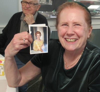Resident showcasing a photo with a big smile.