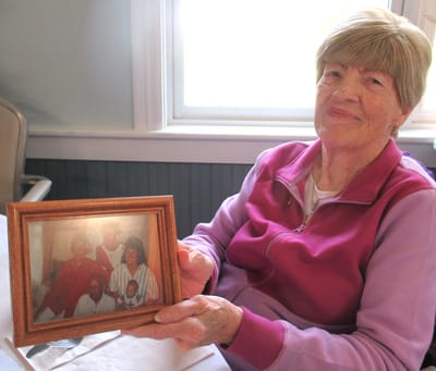 Senior woman holding a family photo.
