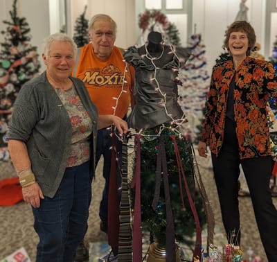 Residents celebrating around a decorated Christmas tree.