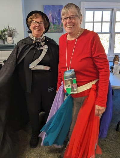 Residents in colorful costumes at an indoor event.