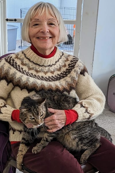 Woman smiling with a cat on her lap