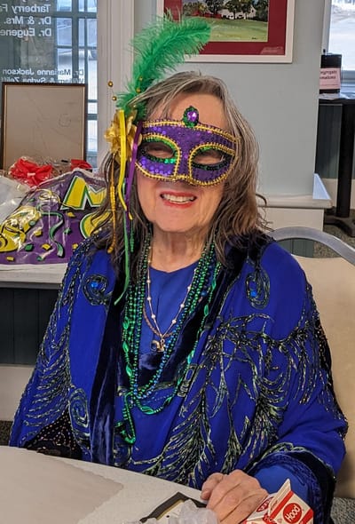 Resident celebrating at a festive event with a mask.