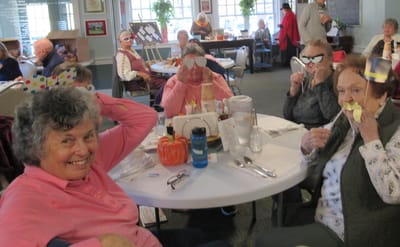 Residents enjoying a playful activity in the dining room.