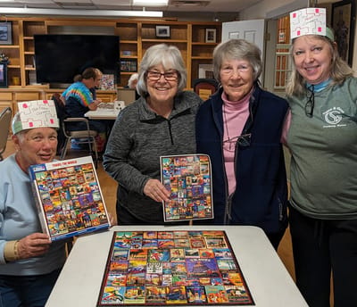 Residents enjoy a group puzzle activity together.
