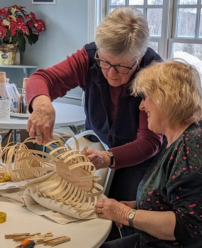 Two residents engaged in a craft activity indoors.