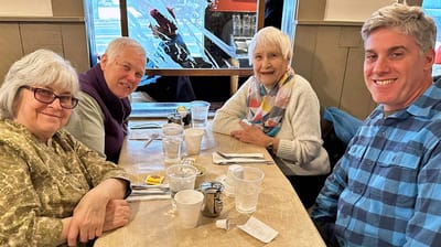 Four residents enjoying a meal together at a table.