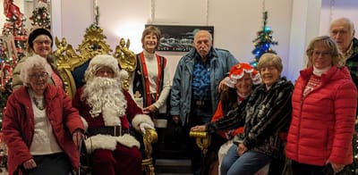 Residents and staff pose with Santa at a holiday event.