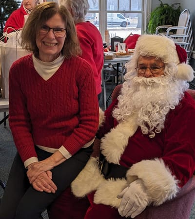 Resident with Santa Claus during a holiday celebration.