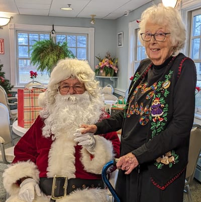 Resident sits with Santa Claus during celebration.
