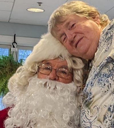 Resident and Santa smiling together indoors