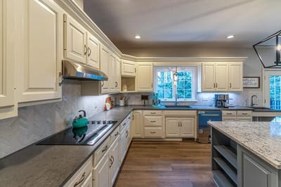 Modern kitchen interior with light cabinetry and granite countertops