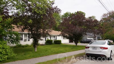 Exterior view of a senior living facility surrounded by trees