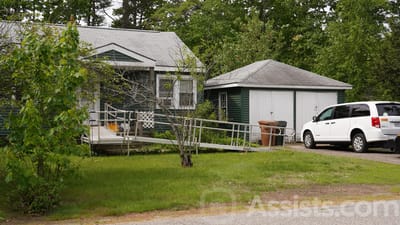 Exterior view of a senior living facility with a vehicle