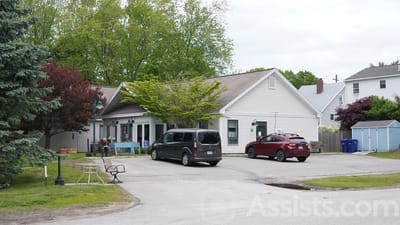 Exterior view of a nursing facility with parked vehicles