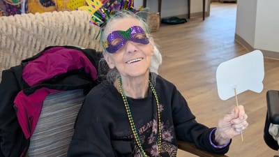 Resident celebrating with festive attire and mask.