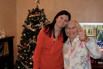 Staff member with resident by a holiday tree