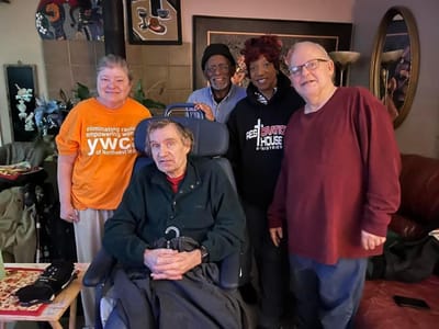 Residents and staff posing together indoors.