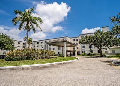 Exterior view of the facility with palm trees