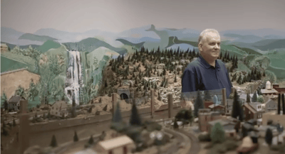 Resident enjoying a detailed model train display.