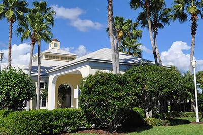 Exterior view of the facility surrounded by palm trees.