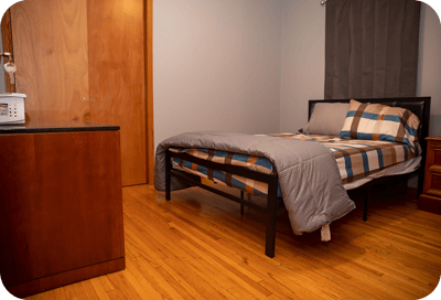 A simple bedroom setup with a bed and dresser.