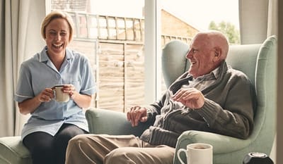 Staff member laughing with elderly resident