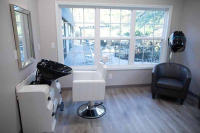 Hair salon area with a chair and sink.