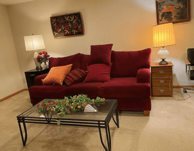 Cozy living space with red couch and lamp.