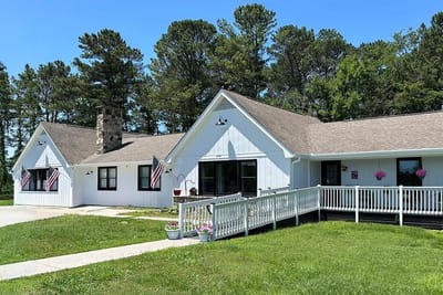 Exterior view of the facility with flags and flowers.